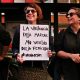 Mujer con cartel en marcha feminsita que dice "La violencia deja marcas, no verlas deja femicidios #niunamenos"