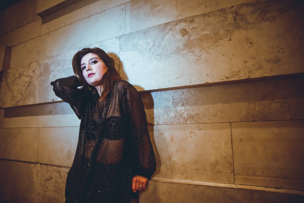 Cantante y compositora chilena Kurmi posando apoyada en una pared